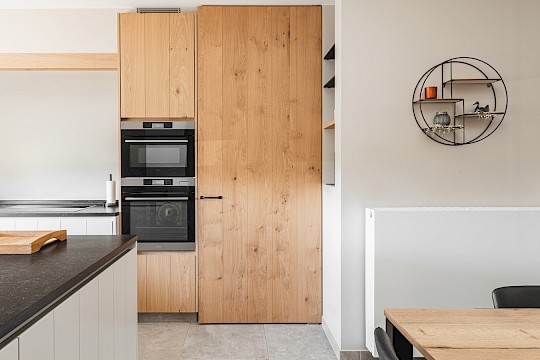 Keuken: zicht op kolomkast met oven, microgolf en koelkast