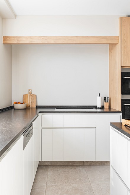 Keuken: zicht op het zwarte werkblad op witte kasten